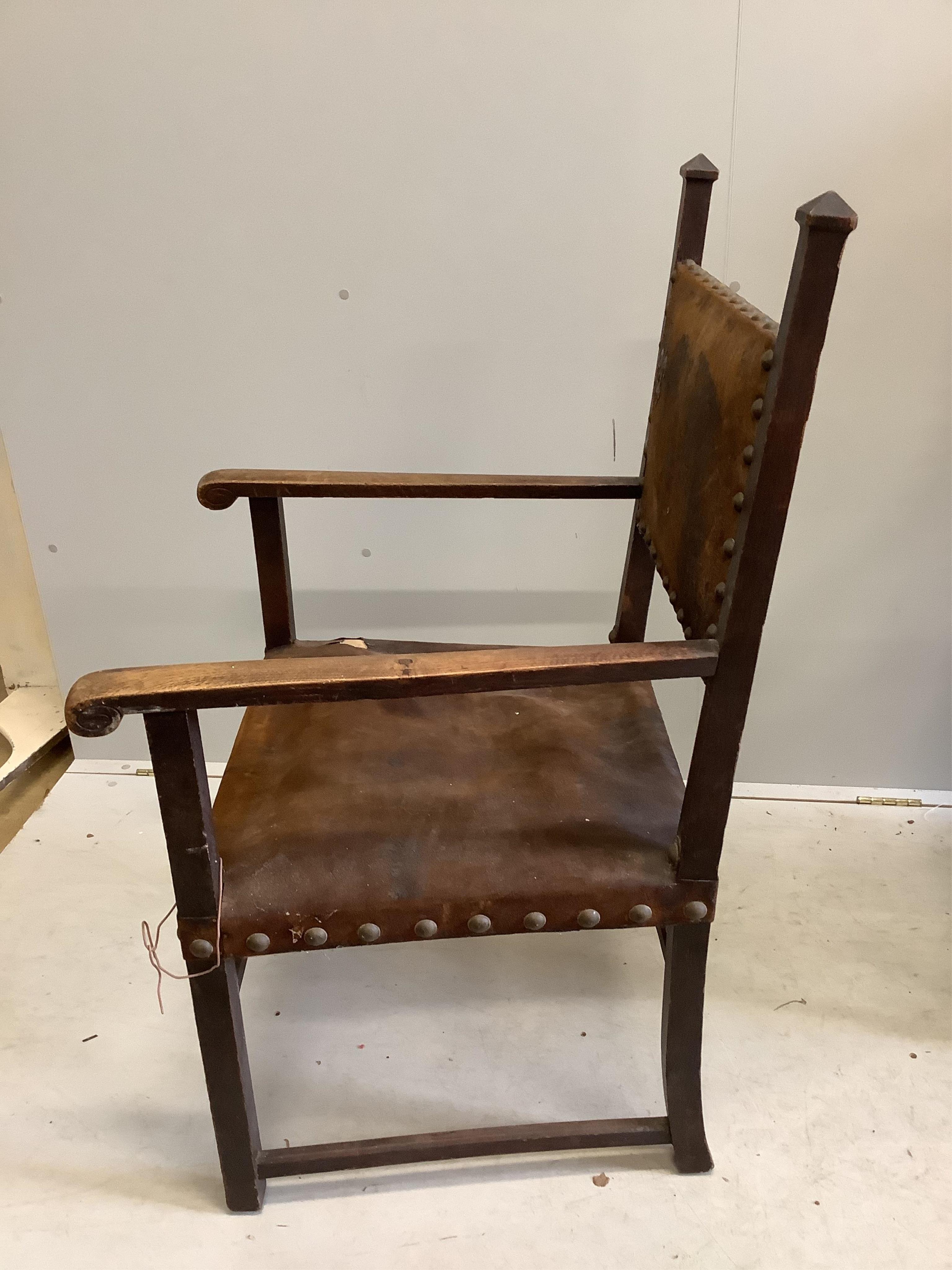 Two late 19th century Flemish carved oak dining chairs, one with arms, together with a Spanish style oak and leather elbow chair. Condition - fair to good